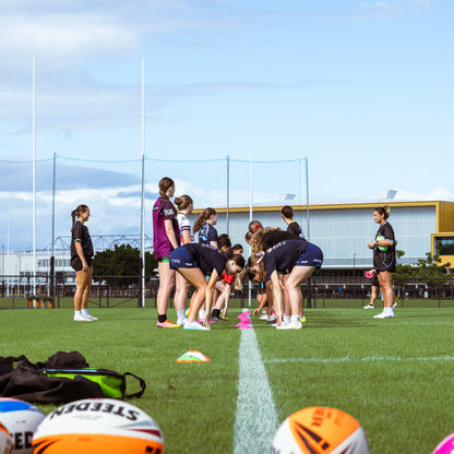 Group of young rugby league players on the sideline picking up cones during game